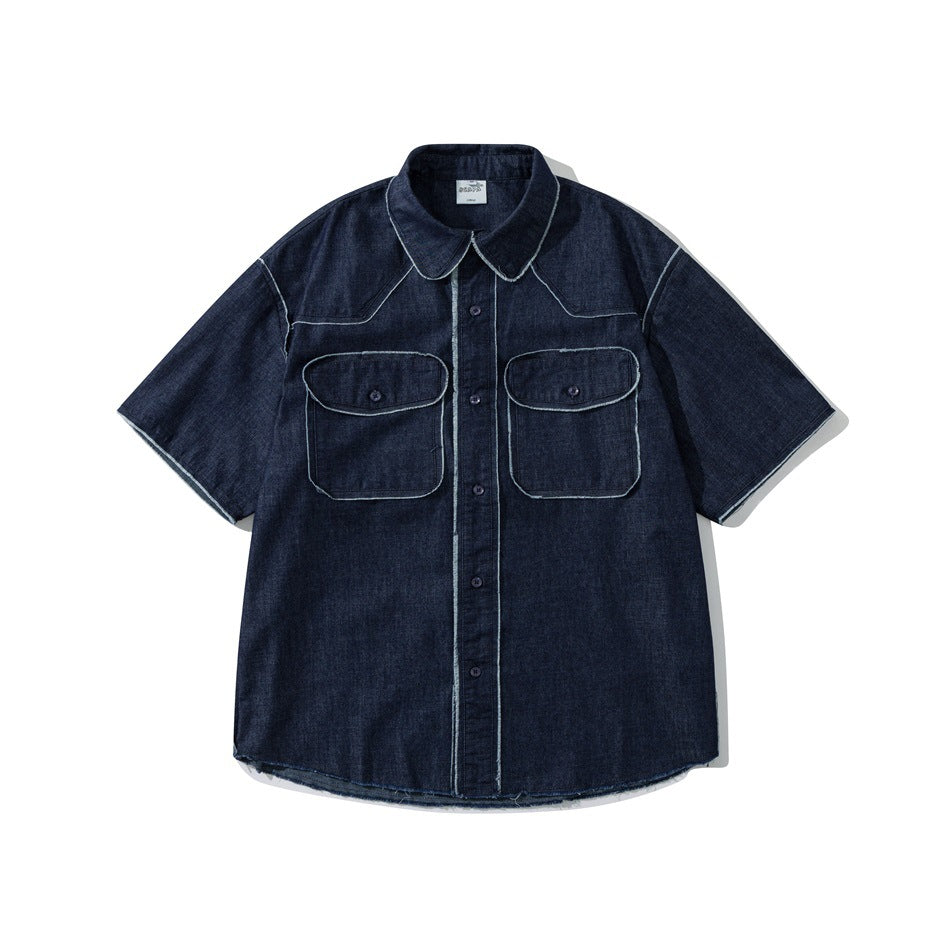 Dark blue short-sleeve denim shirt with two flap chest pockets and frayed light seam trim, flat front view