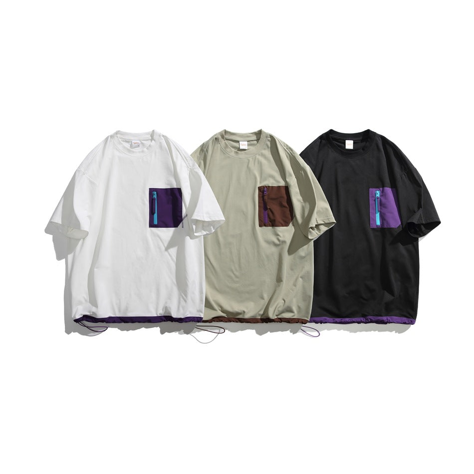 Three short-sleeve T-shirts shown flat in white, light khaki, and black, each with a contrasting zip chest pocket.