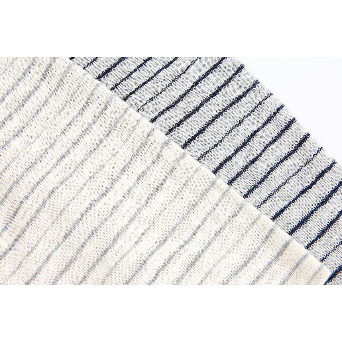 Close-up of two light shirts with different narrow stripe colors, highlighting the knit texture.
