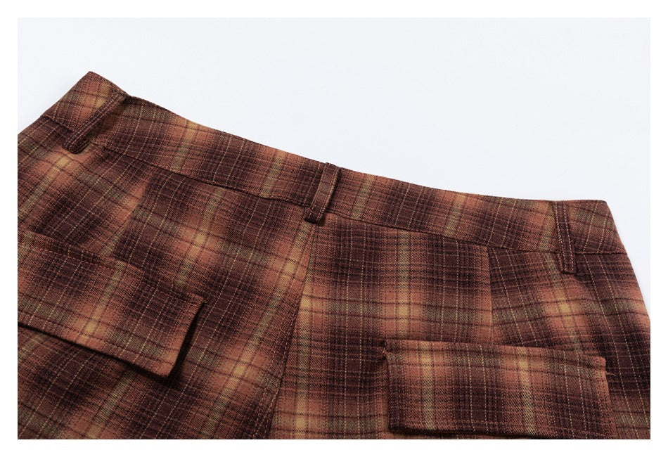 Close-up of the waistband, belt loops, and back pockets on brown and tan plaid trousers.