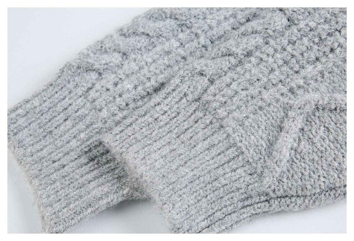 Close-up of a light gray sweater with textured knit and a ribbed edge.