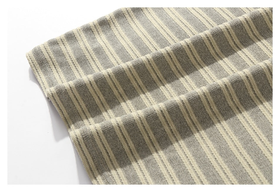 Close-up of gray and cream striped fabric folded to show its textured surface and edge.