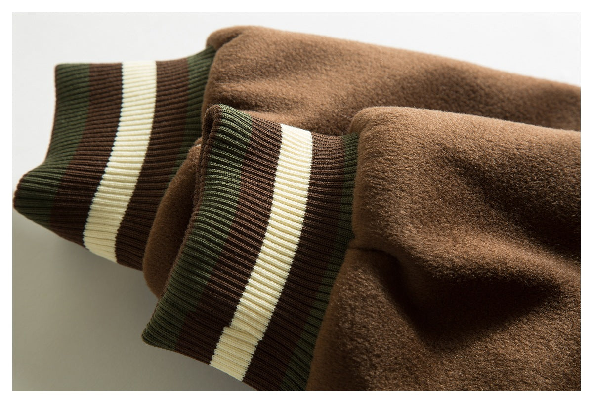 Close-up of brown jacket sleeves with ribbed cuffs striped in dark green, cream, and brown.