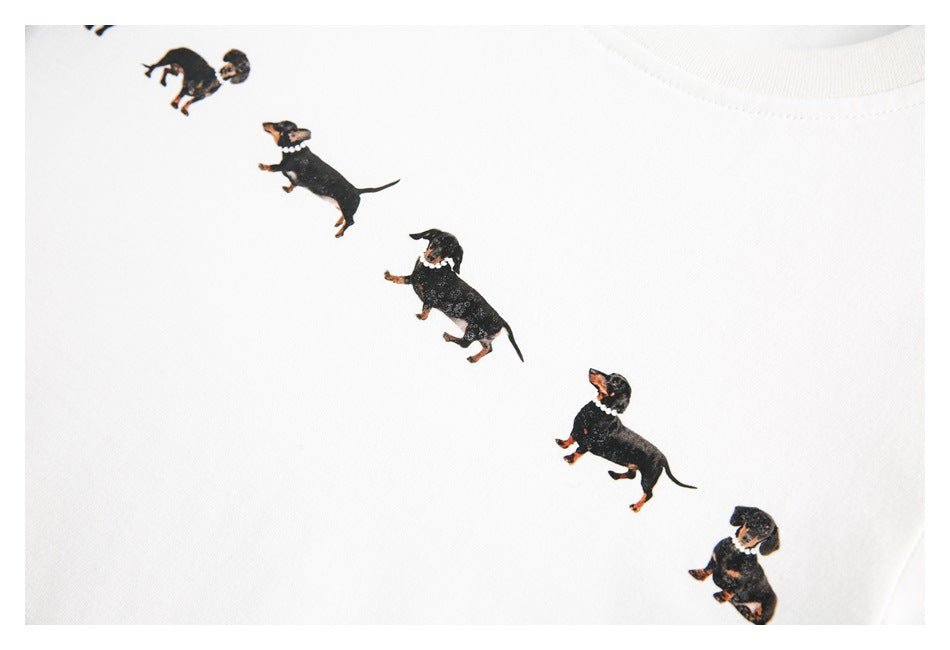 Closer view of the black-and-tan dachshund print arranged diagonally on a white T-shirt.