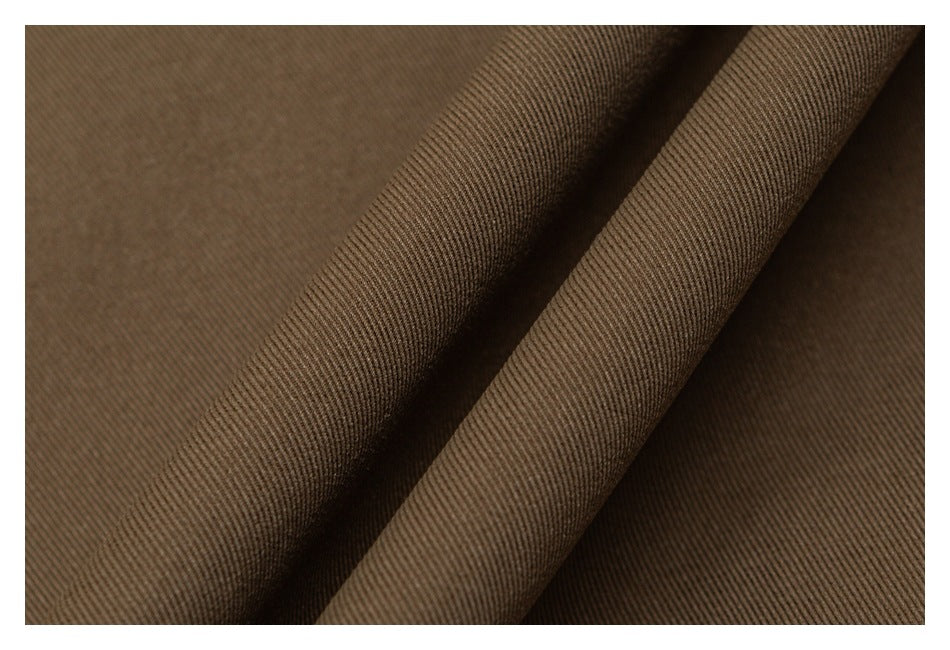 Close-up of brown fabric with a fine diagonal weave and soft folds.