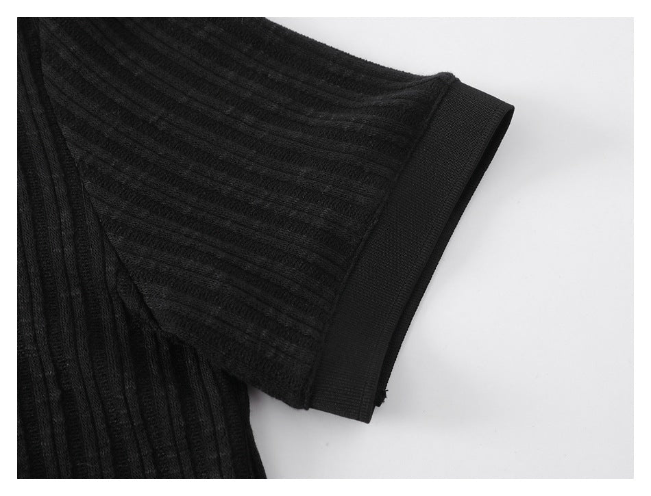 Close-up of a black ribbed sleeve with a wide fitted cuff.