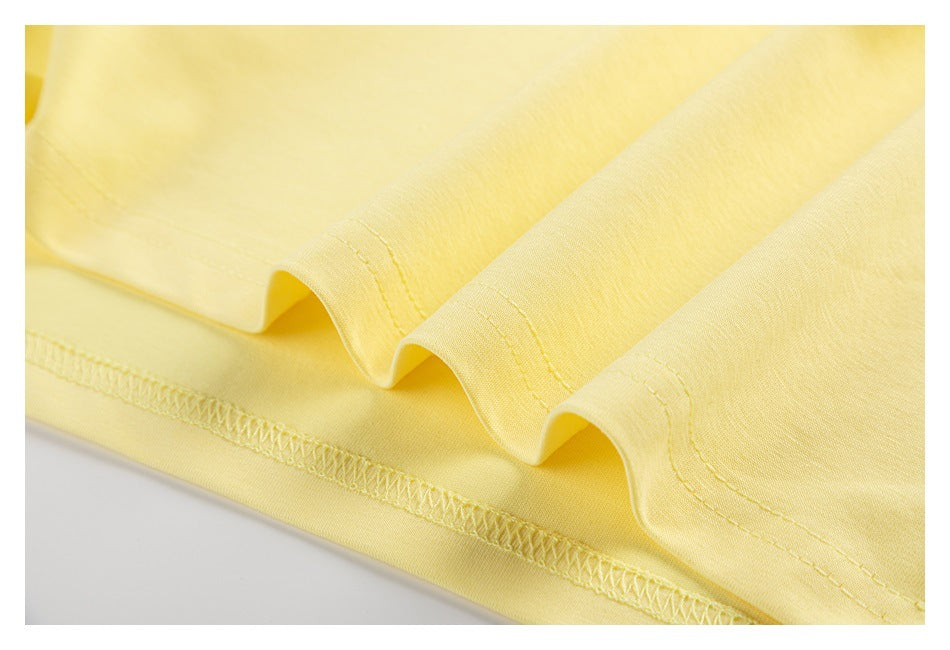 Close-up of the pale yellow T-shirt’s stitched lower hem.