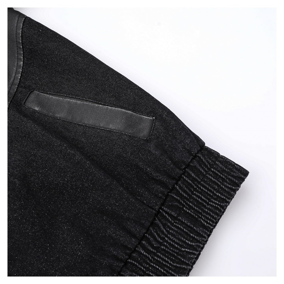Close-up of the black jacket's dark denim sleeve panel, smooth trim, and gathered ribbed cuff.