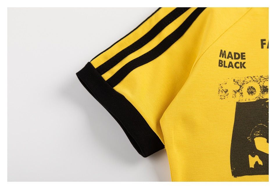 Close-up of a yellow sleeve with three black stripes and a black cuff.