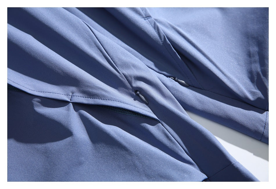 Close-up of slate blue pants with stitched seams and small zipper pulls.