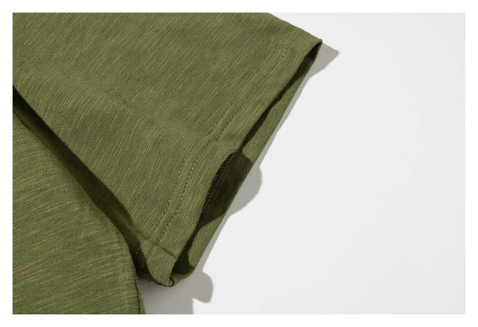 Close-up of the olive green T-shirt sleeve and its double-stitched hem.