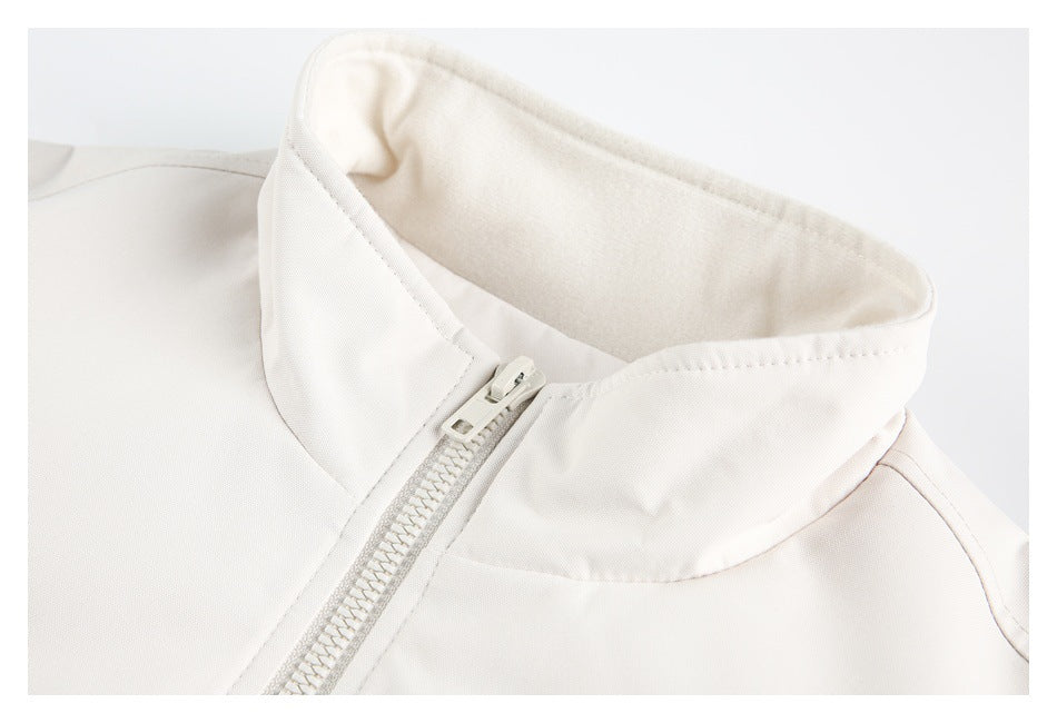 Close-up of an off-white jacket's stand collar, zipper, and soft-looking inner collar surface.