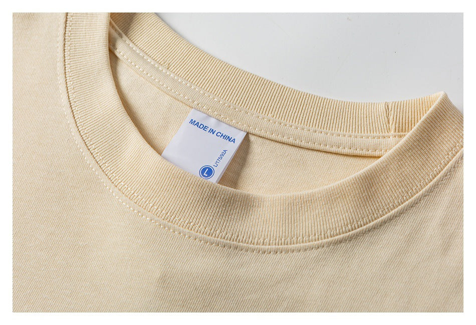 Close-up of the beige T-shirt's ribbed crew neckline and inner label marked Made in China.