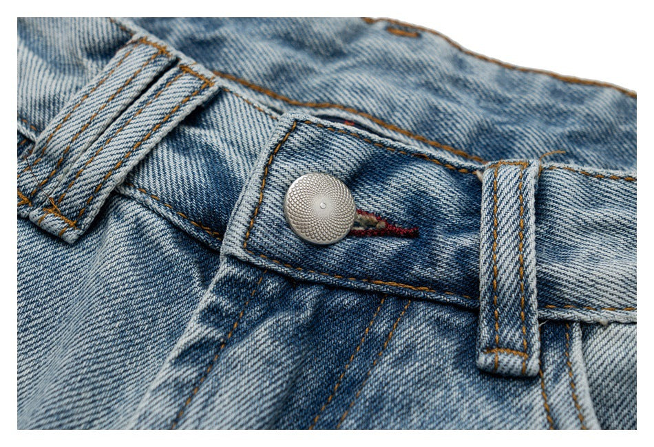 Close-up of the jeans' metal waist button, belt loop, and contrast stitching.