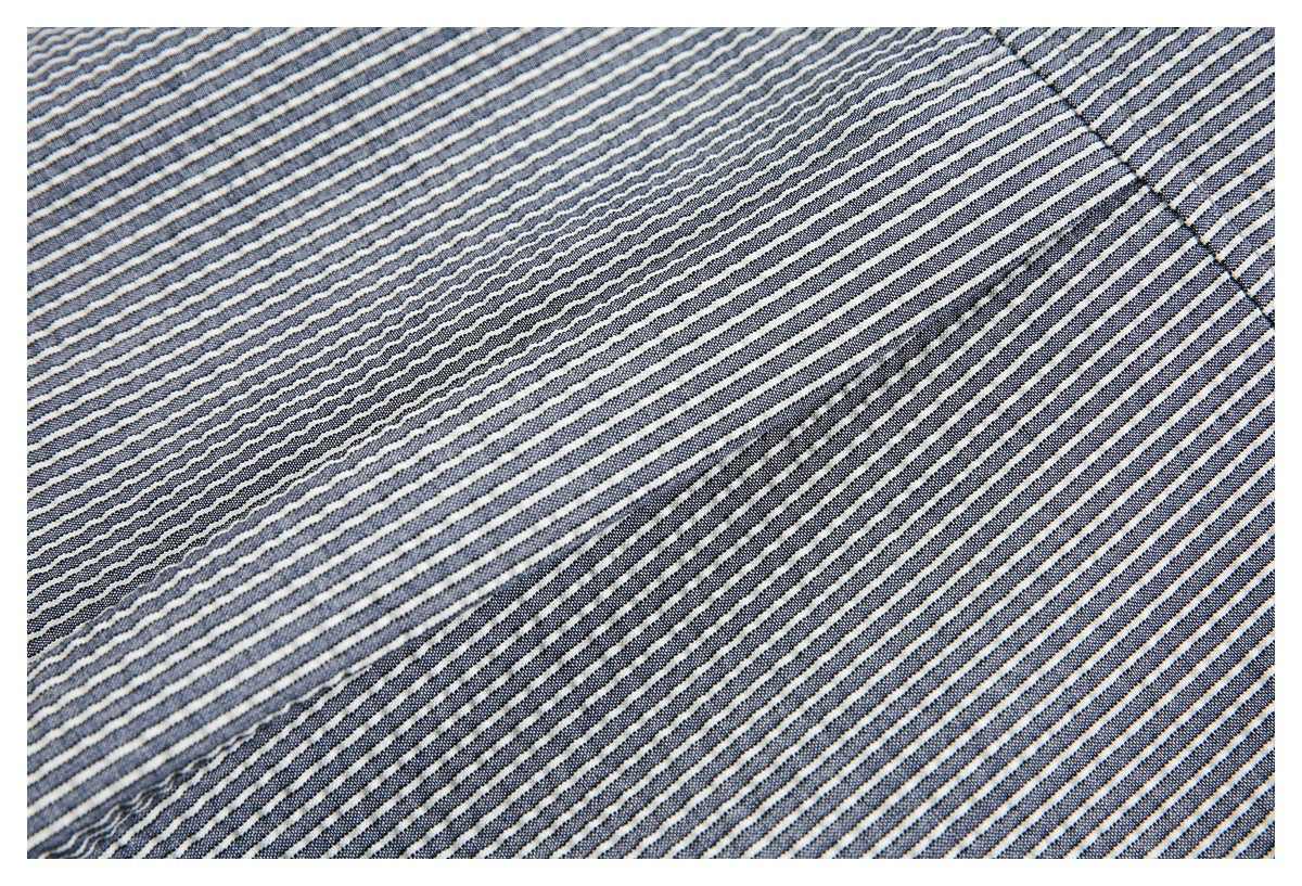 Close-up of navy and white narrow-striped fabric with a diagonal stitched seam.