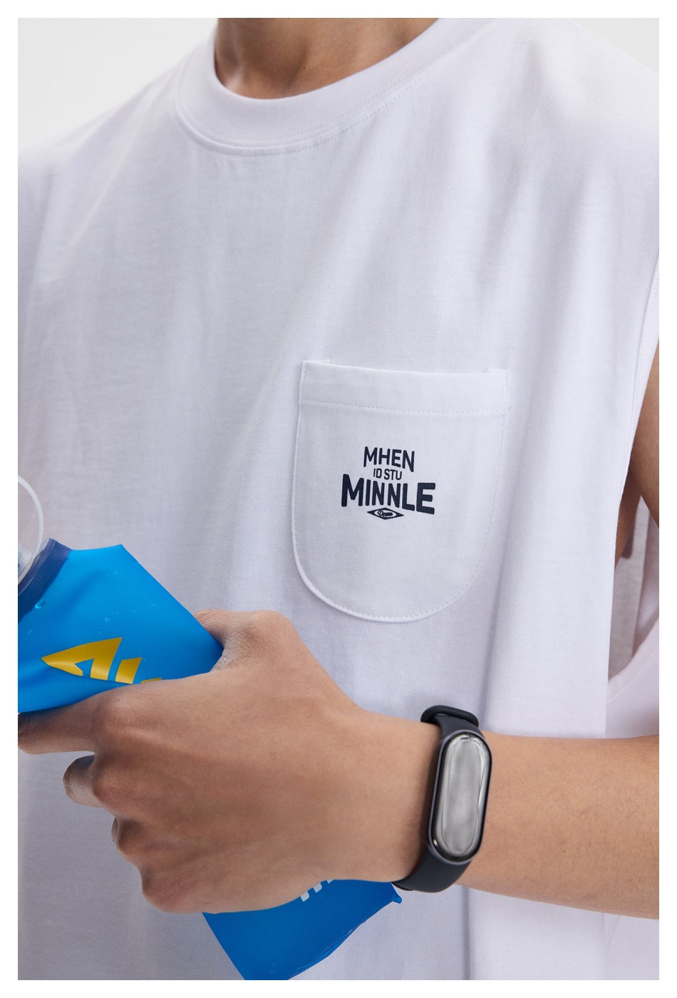 Close-up of a white sleeveless shirt's chest pocket with small dark lettering and stitching.