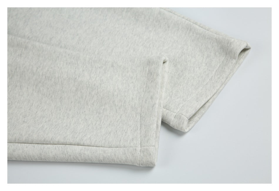 Close-up of the stitched hem on light heather gray shorts.