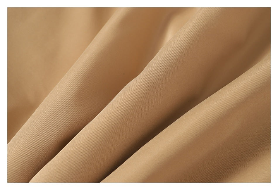 Close-up of the tan jacket fabric arranged in soft folds.