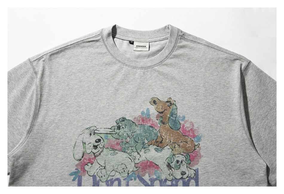 Close view of a light gray T-shirt front with a faded, colorful cartoon dog print.