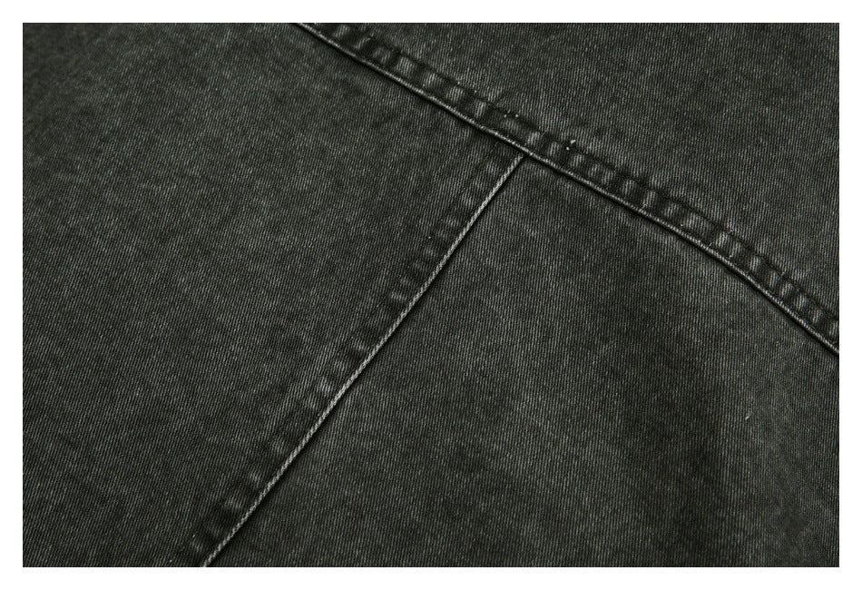 Close-up of charcoal-black garment panels and intersecting stitched seams.