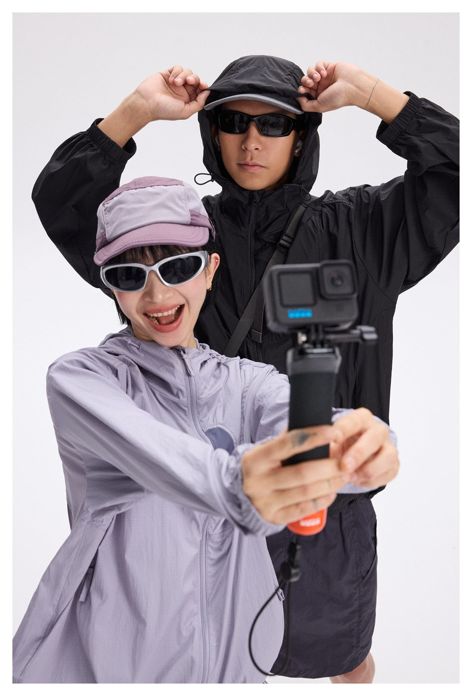 Two models pose in pale lavender and black hooded jackets.
