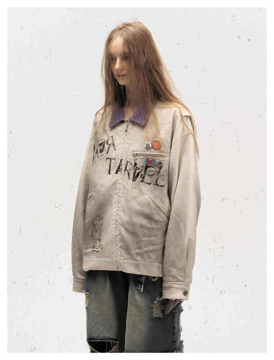 Three-quarter front view of a model in a distressed beige jacket with a purple collar and chest graphics.