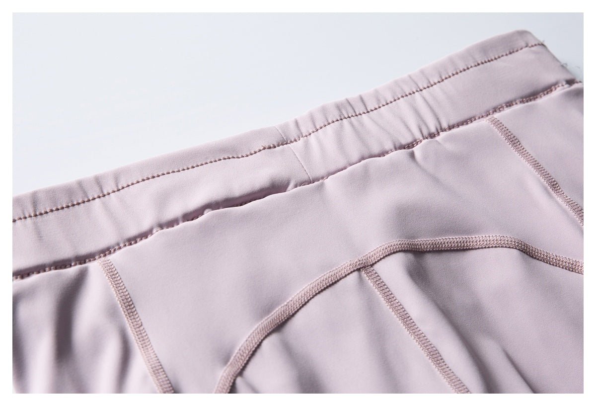 Close-up of a pale lavender garment waistband and curved stitched panel seams.