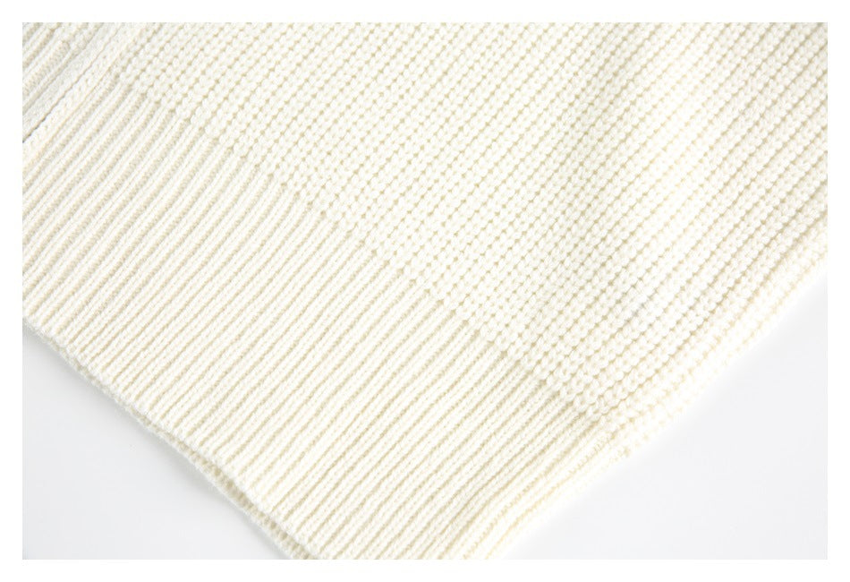 Close-up of the ribbed edge and chunky knit texture of a cream garment.