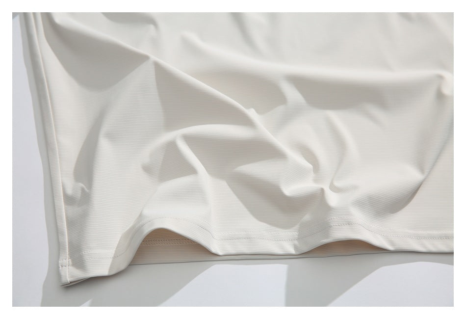 Close-up of the white shirt’s stitched bottom hem and textured fabric.