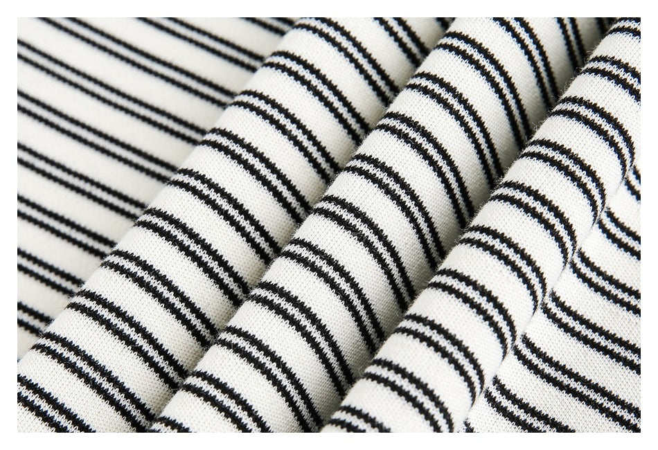 Close-up of black-and-off-white striped garment fabric arranged in folds.