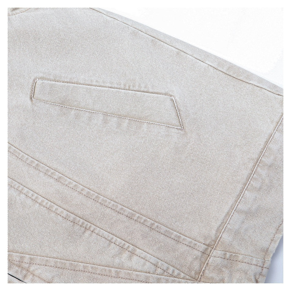 Close-up of a narrow welt pocket and stitched panel seams on a light beige jacket.
