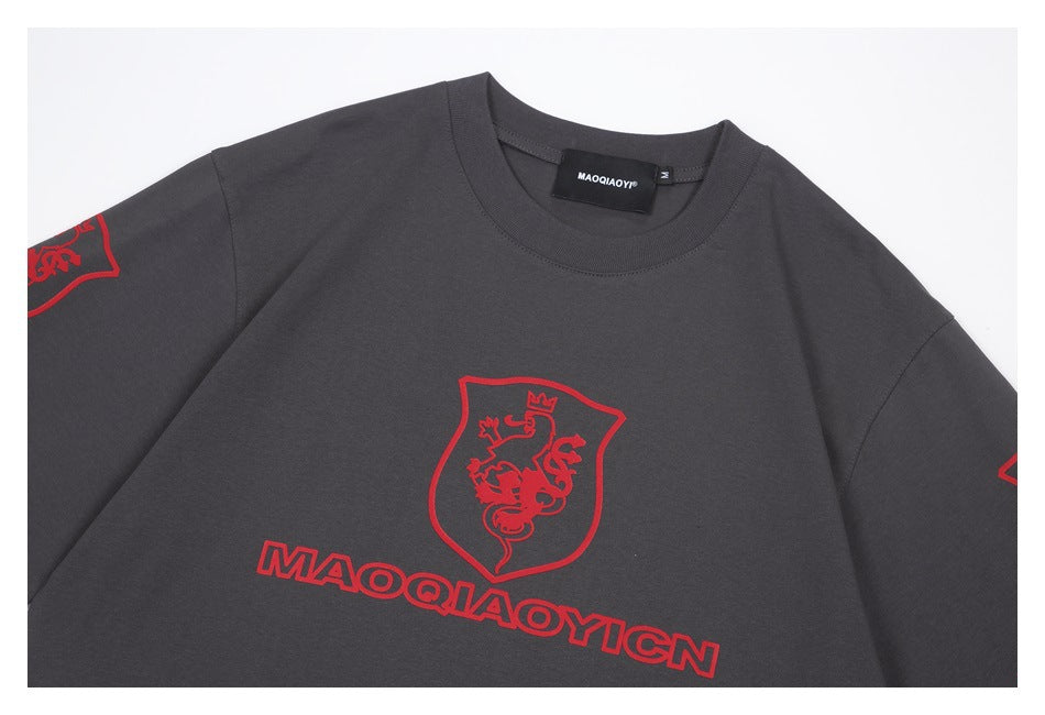 Close-up of a charcoal sweatshirt front with a red crowned-lion crest and outlined lettering.