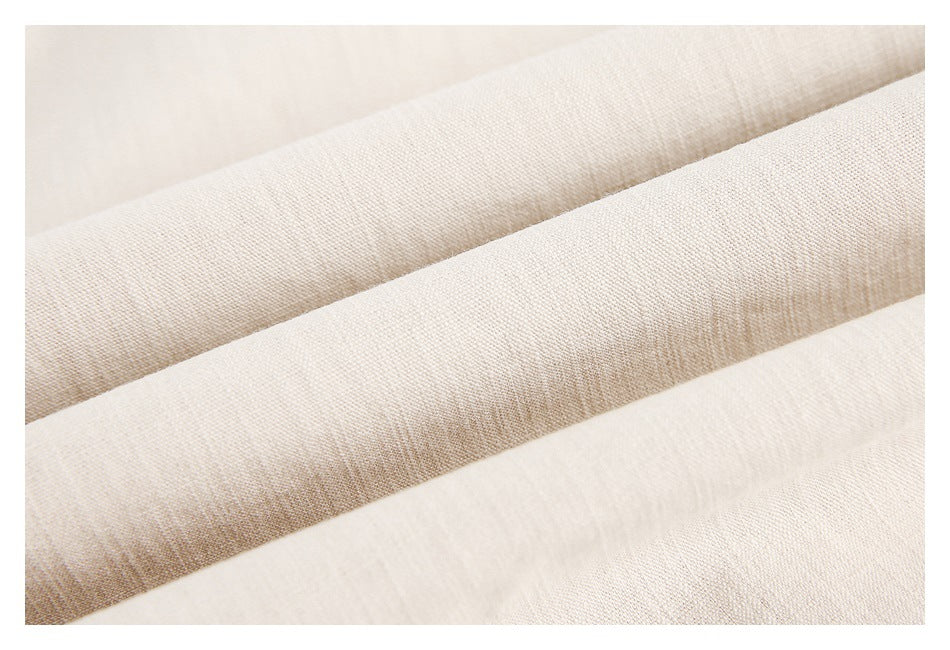 Macro view of softly folded beige fabric showing its woven texture.