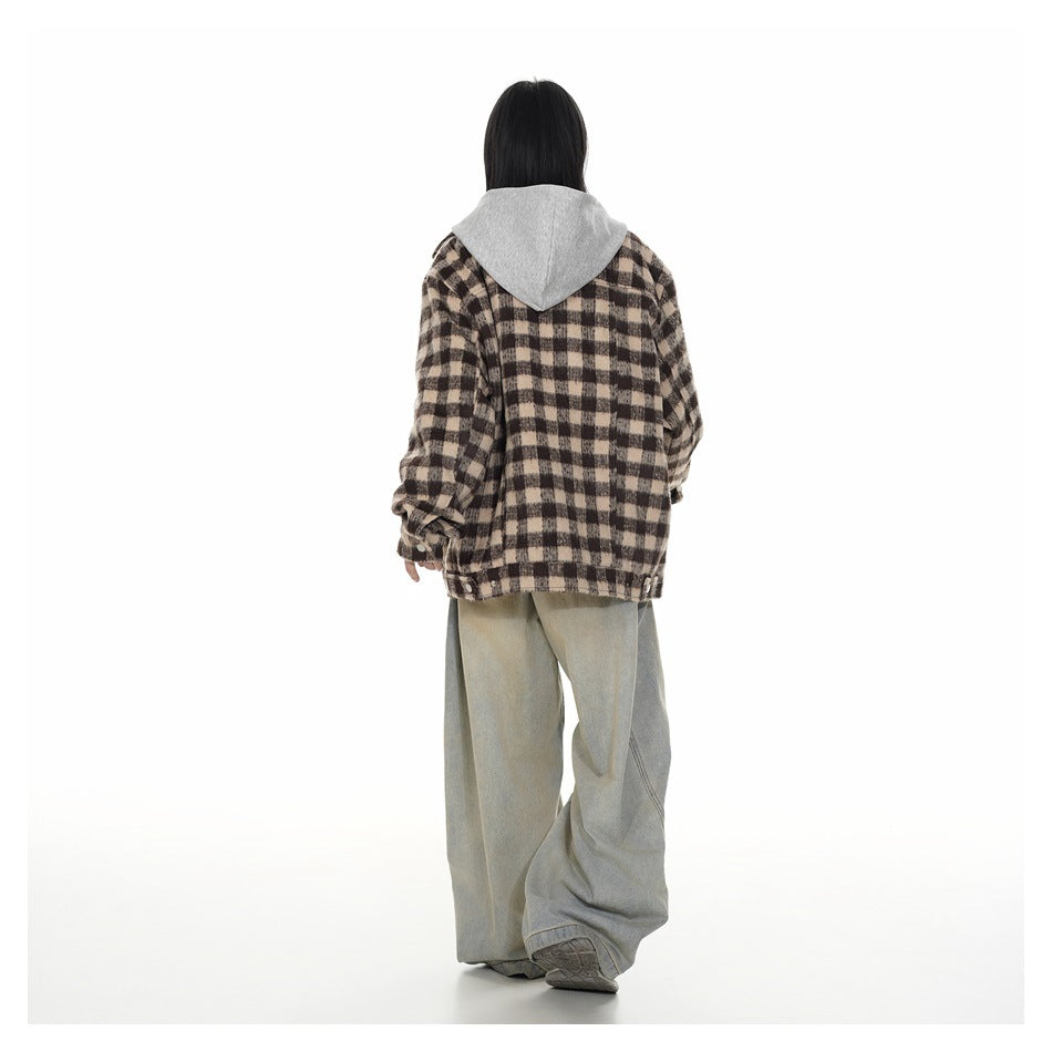 Back view of a model wearing a brown and beige plaid hooded jacket with loose light-wash jeans.