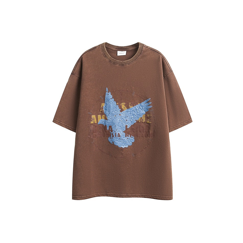 Brown short-sleeve crew-neck T-shirt with textured blue bird graphic and yellow and maroon lettering, flat front view