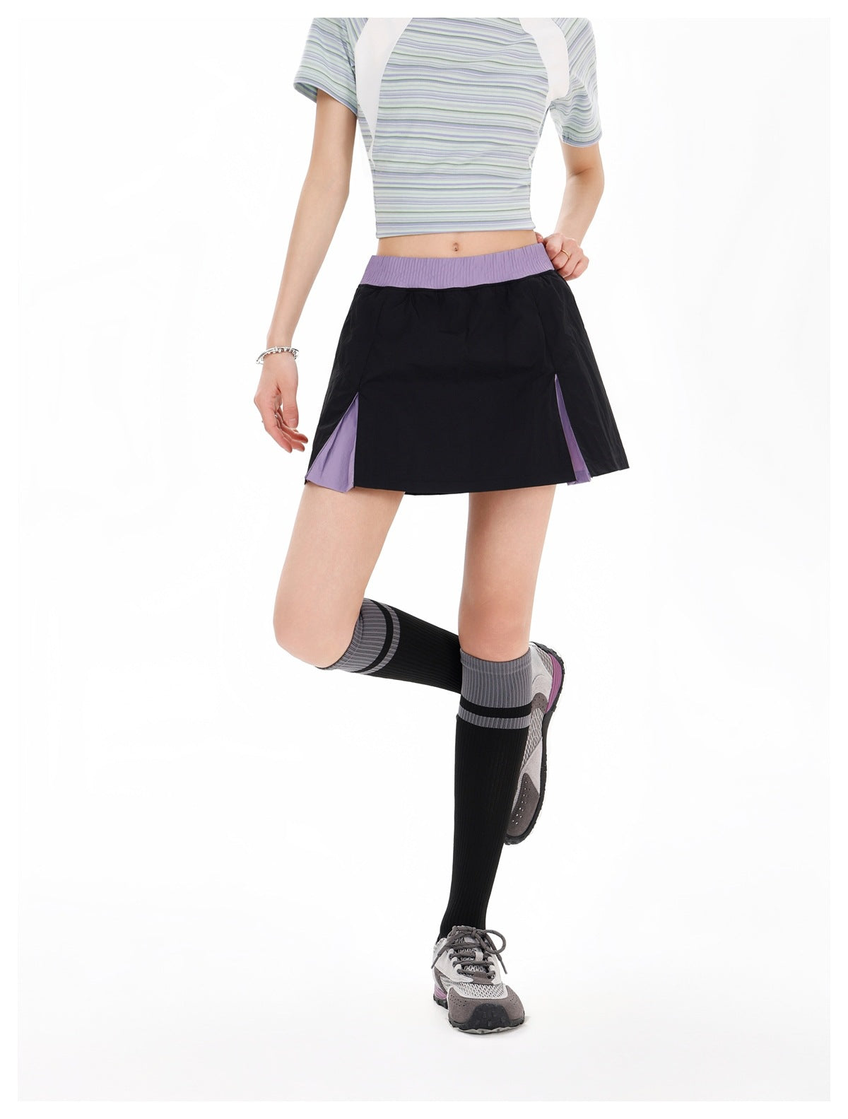 Model in a black flared skirt with a lavender waistband and contrasting lavender inserts at the side openings.
