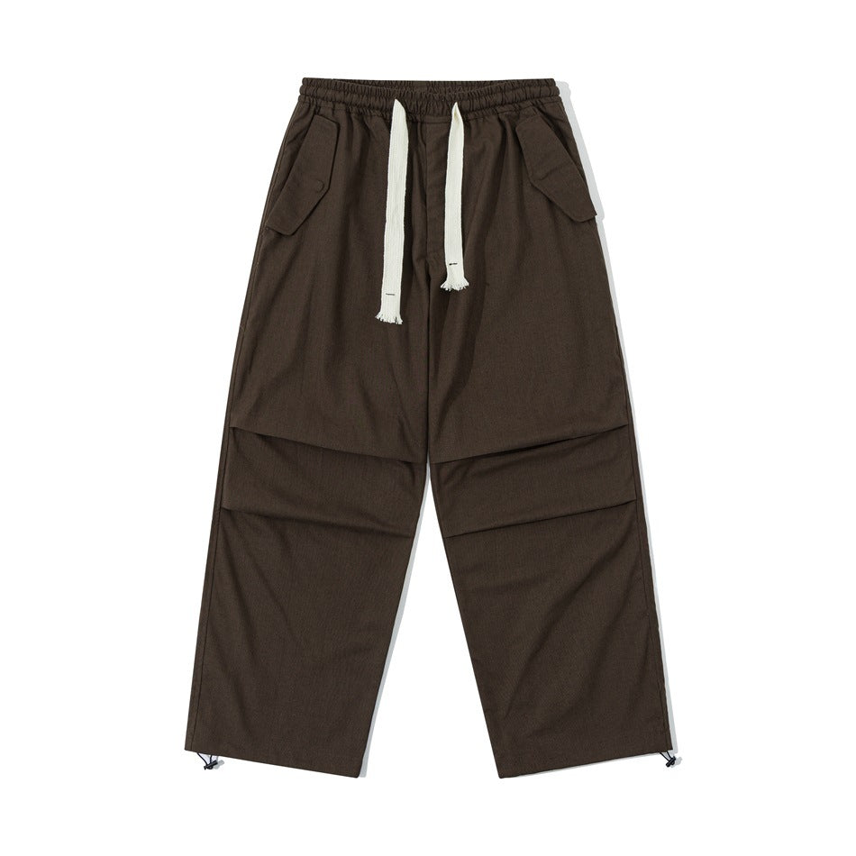 Brown wide-leg drawstring pants with hip flap pockets, knee pleats and hem toggles, front flat view