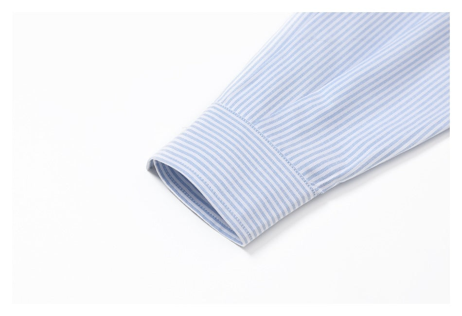 Close-up of a blue-and-white striped shirt sleeve ending in a buttonless cuff.