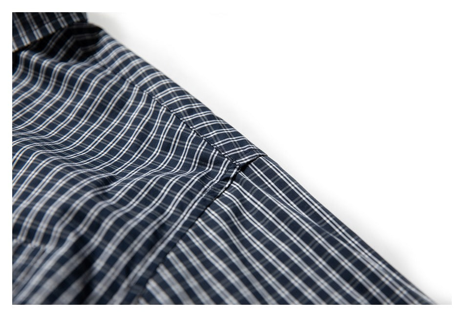 Close-up of the navy plaid shirt shoulder seam and sleeve.
