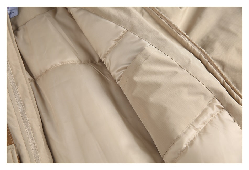 Close-up of the jacket's beige quilted lining and interior pocket; a small label is partly visible.