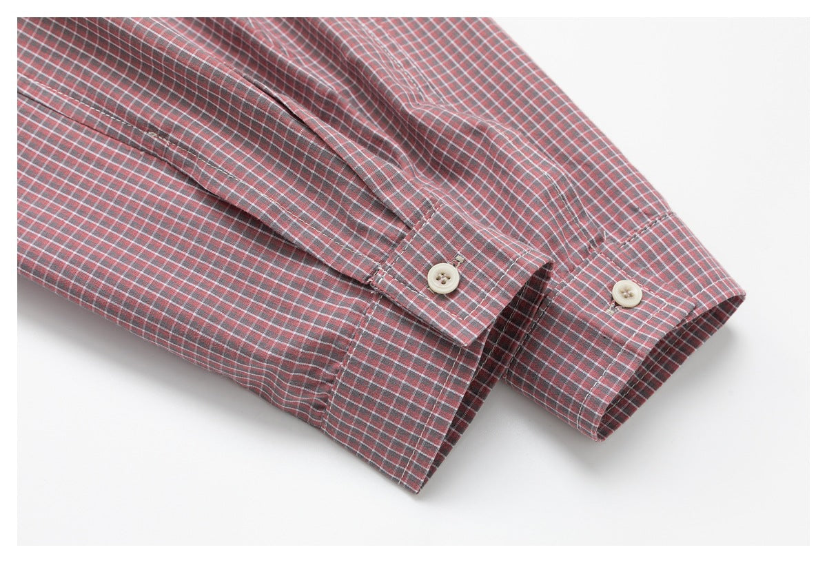 Close-up of a red plaid shirt sleeve and buttoned cuff against a white background.