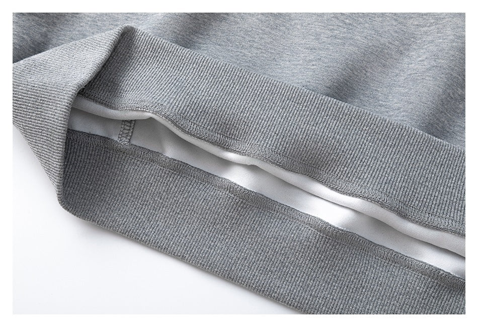 Close-up of the ribbed hem and interior stitching of a gray heather garment.