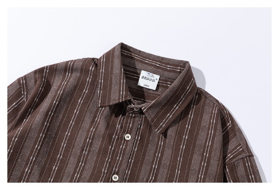 Upper front of a brown striped button-up shirt, showing its collar, buttons, and neck label.