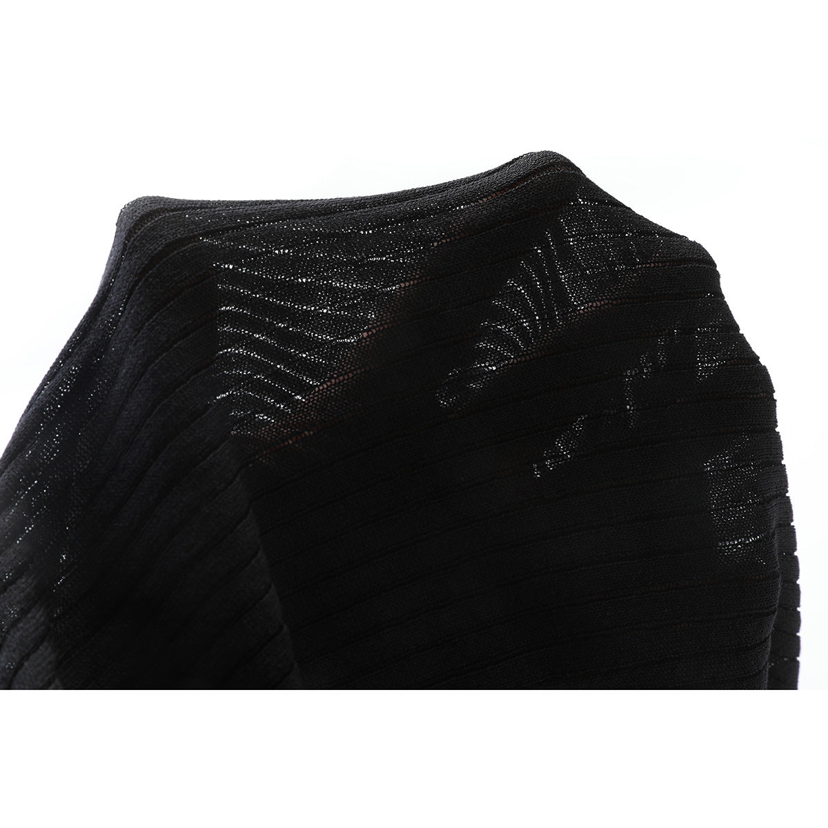 Close-up of black knit fabric showing open, textured stitch patterns.