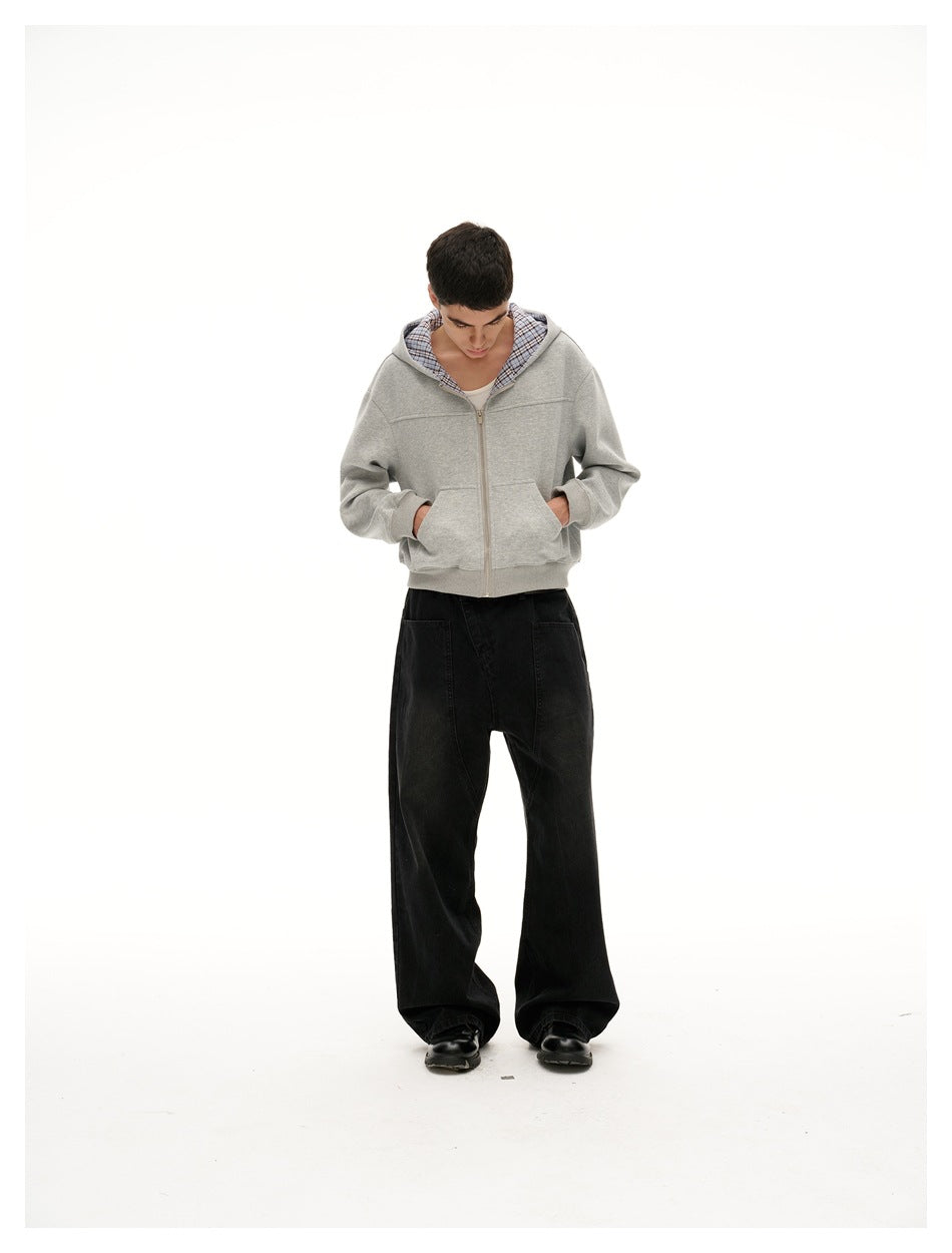 Full-length model wearing a light gray zip-up hoodie with blue plaid hood lining and wide black pants.