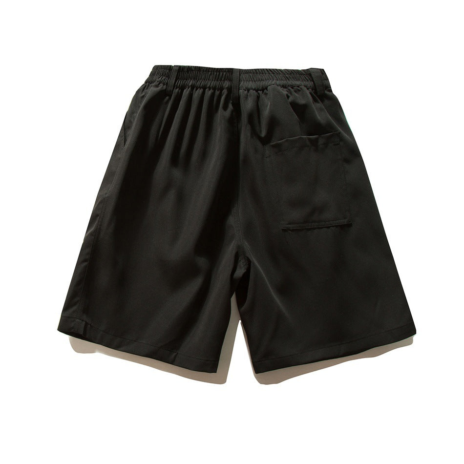 Back view of black wide-leg shorts with elastic waistband and a large patch pocket on the right