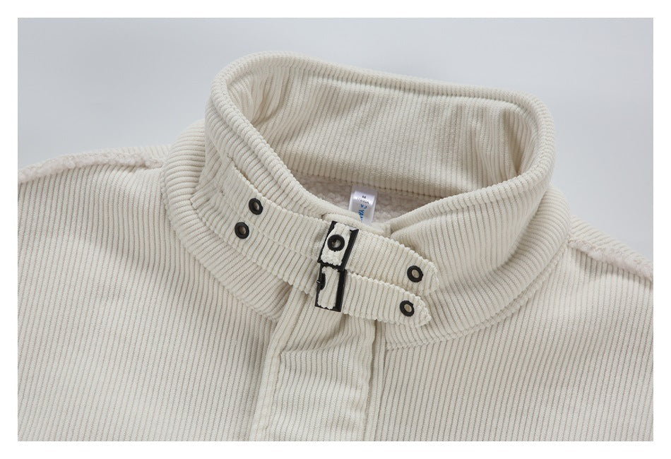 Close-up of a cream ribbed jacket collar with a black buckle closure, snap details and an inner neck label.