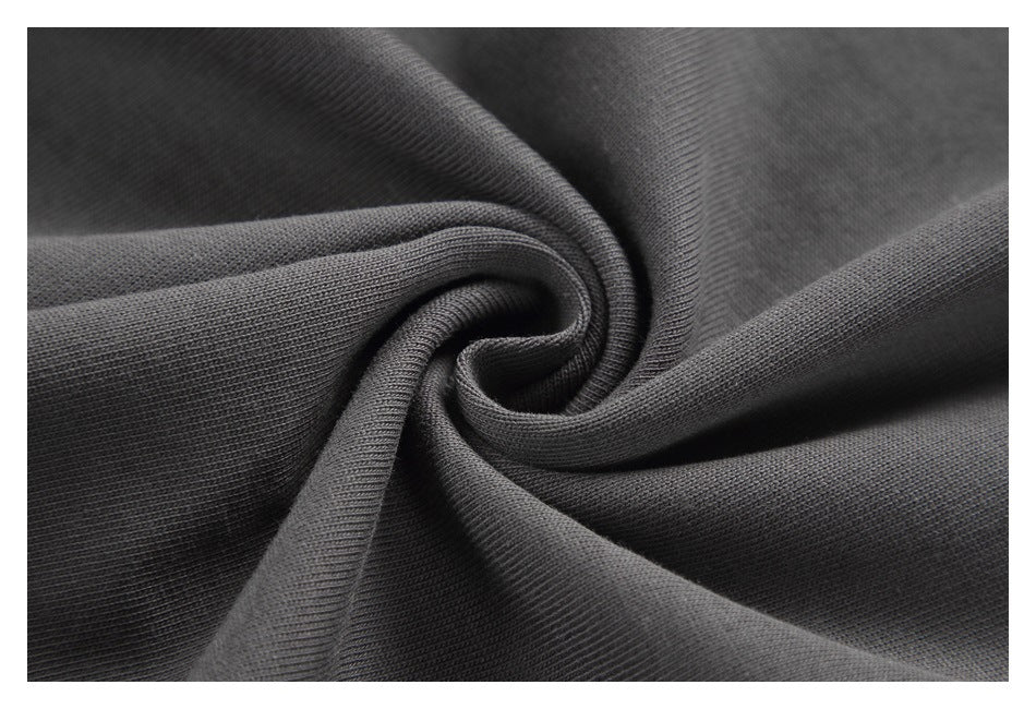 Close-up of dark charcoal fabric gathered into a spiral, showing its fine textured surface.