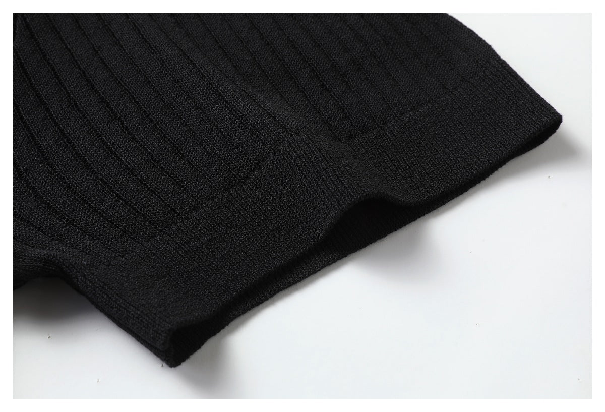 Close-up of the black knit top's sleeve and finished cuff.