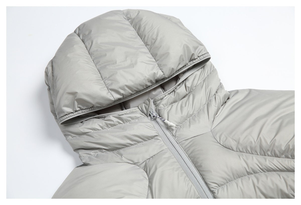 Close-up of a light-gray puffer jacket's hood, collar, and front zipper.